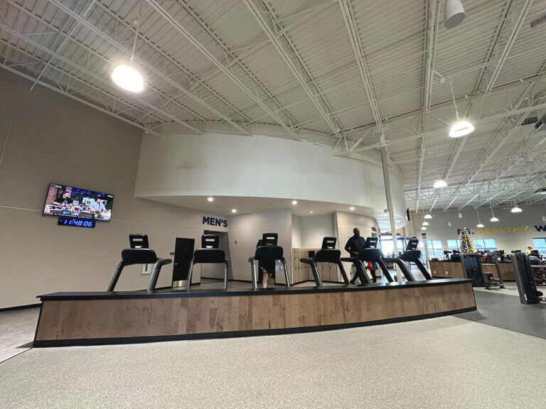Man using gym treadmill in fitness center.