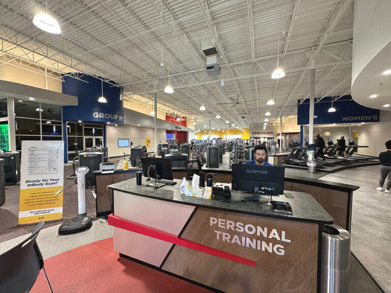 Gym interior with personal training desk and equipment.