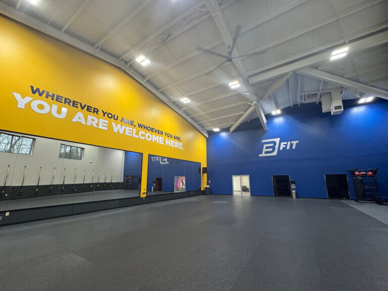 Empty gym interior with motivational message on wall.