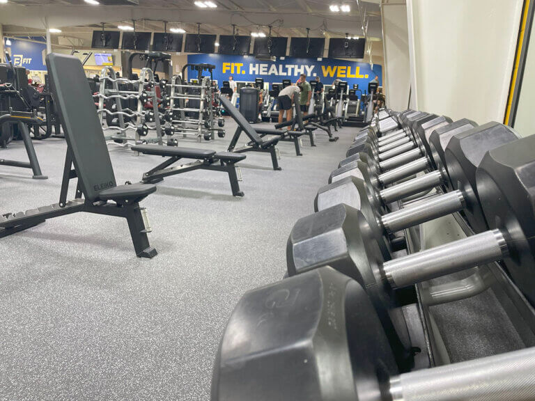 Modern gym with weights and fitness equipment.