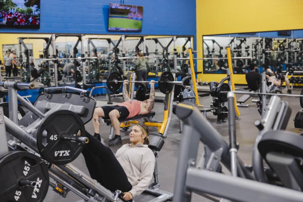 People lifting weights in a gym setting.