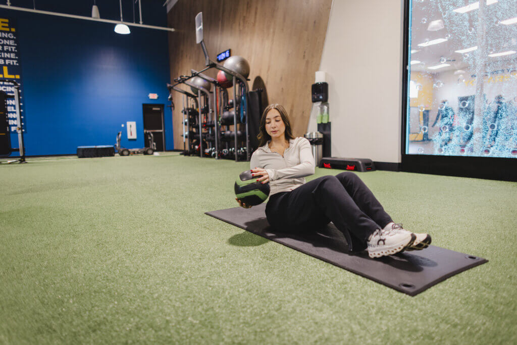 Woman exercising with medicine ball in gym.