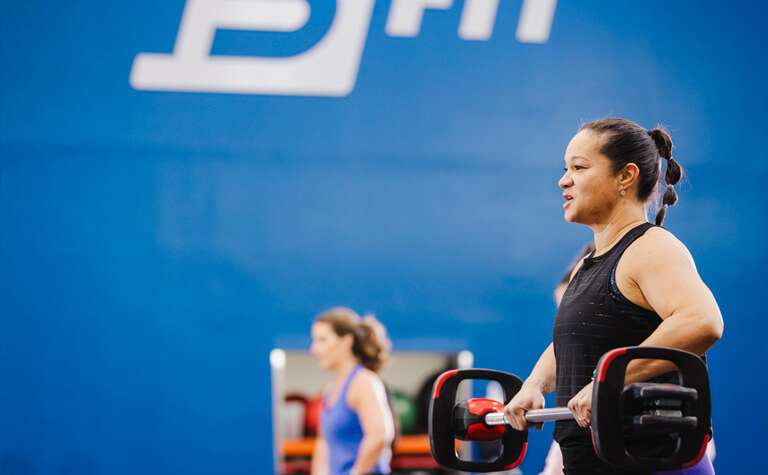 Gym member in group fit strength class in studio